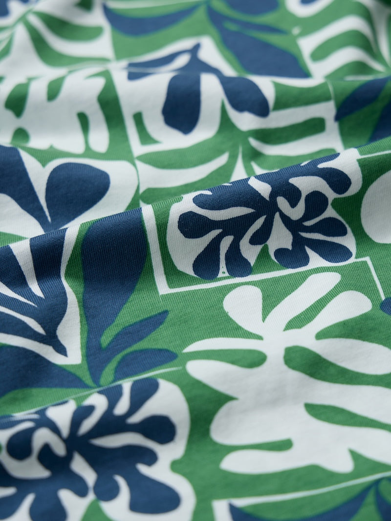 Close-up of fabric with blue and white floral pattern on green background