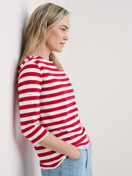 Woman wearing a red and white striped shirt against a plain background