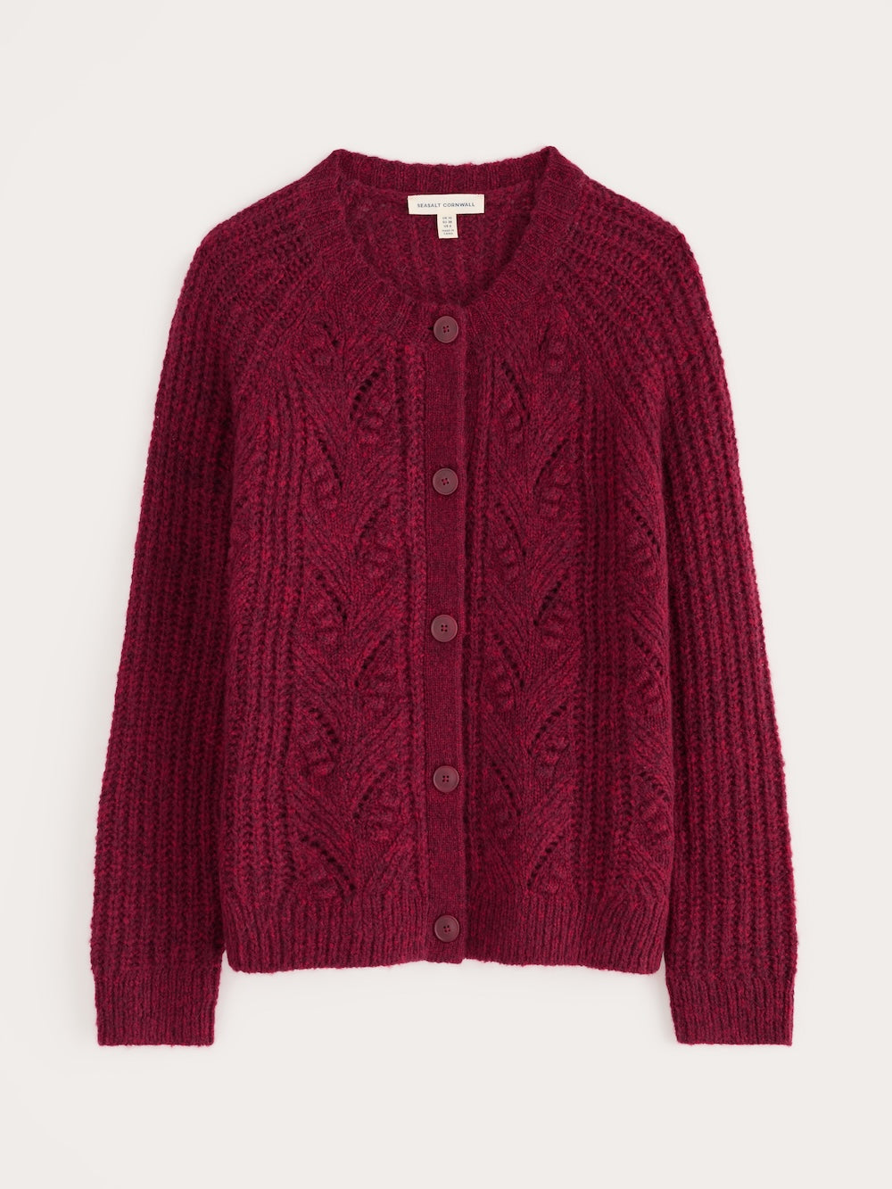 Red knitted cardigan with cable pattern on a white background