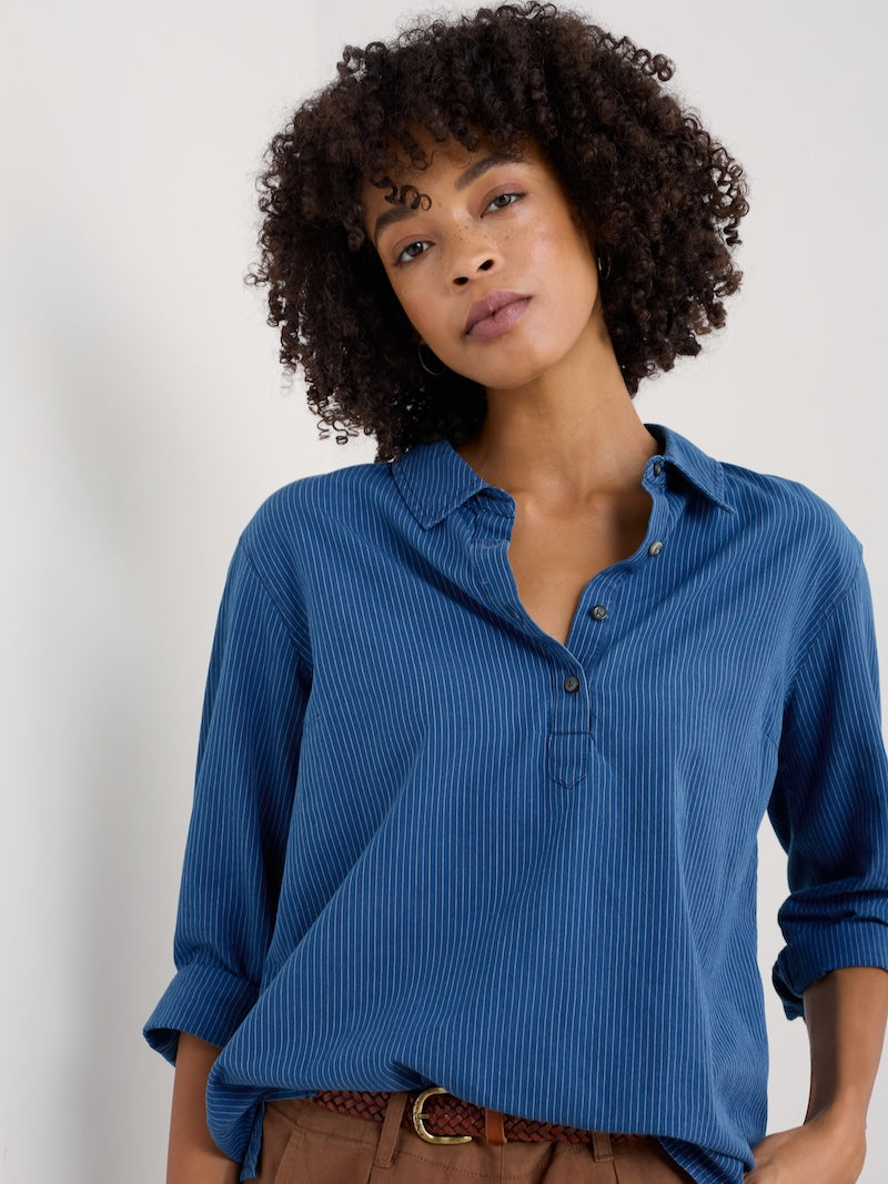 Woman wearing a blue shirt against a plain background
