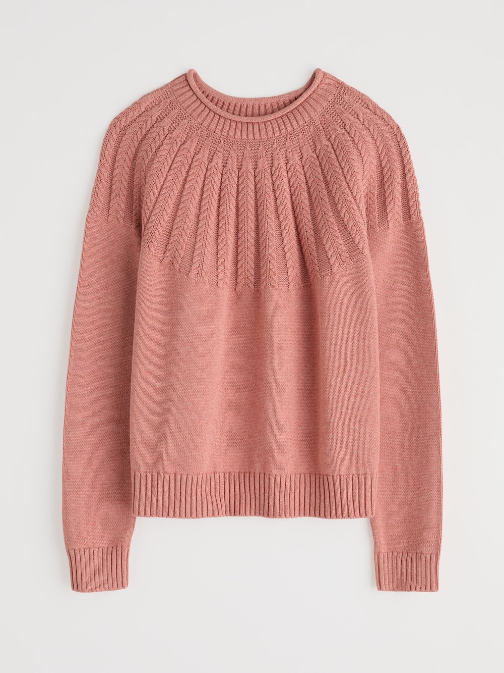 Pink sweater with cable knit pattern on a light gray background