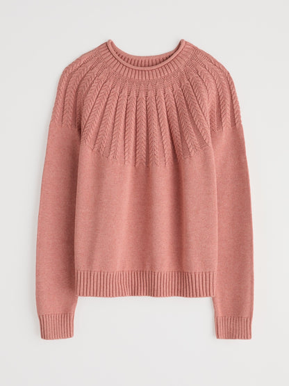 Pink sweater with cable knit pattern on a light gray background