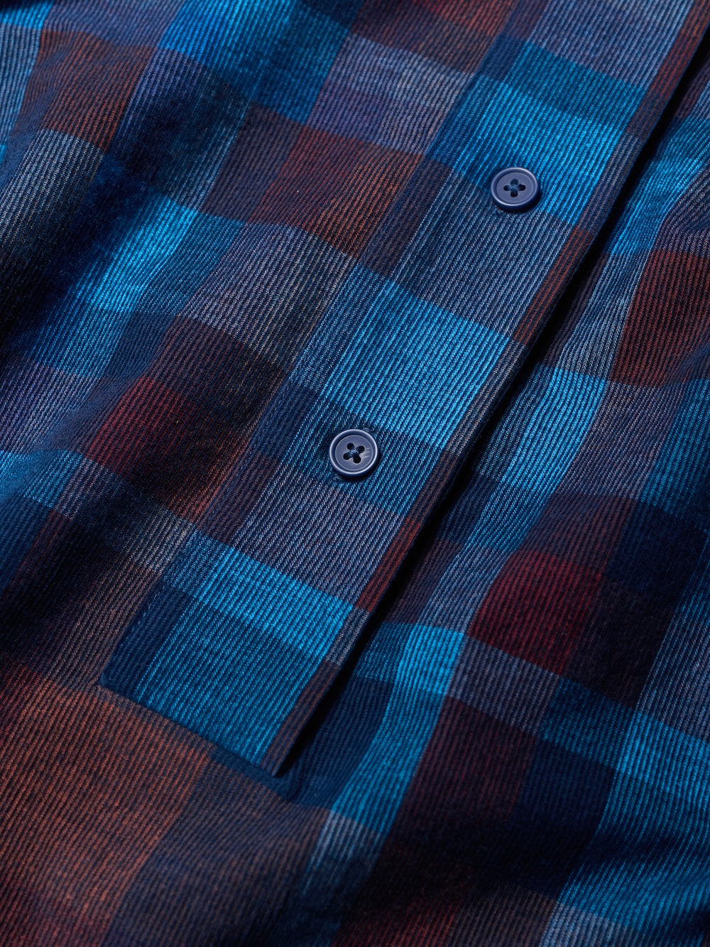 Close-up of a blue and brown plaid shirt with button details
