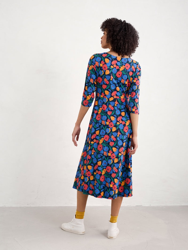 Woman wearing a colourful floral dress against a white background