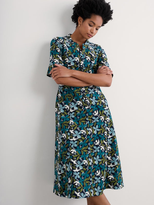 Woman wearing a floral dress against a plain background