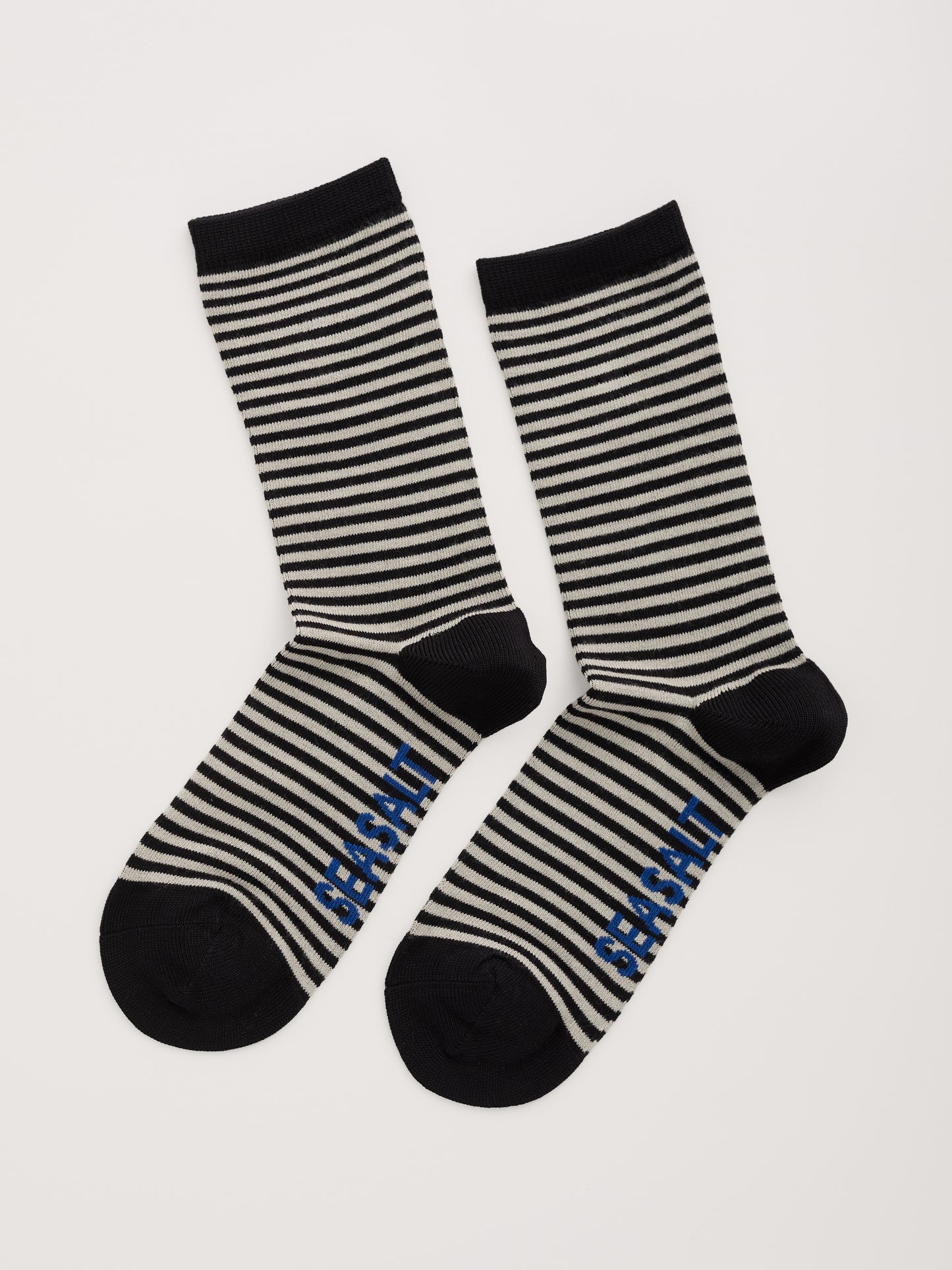Black and white striped socks with 'Seasalt' branding on a light gray background