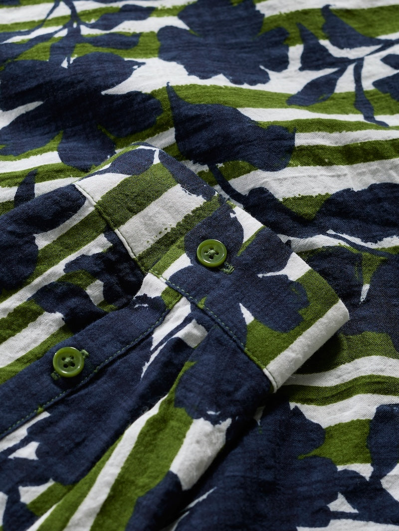 Close-up of a floral patterned fabric with blue, green, and white colors.