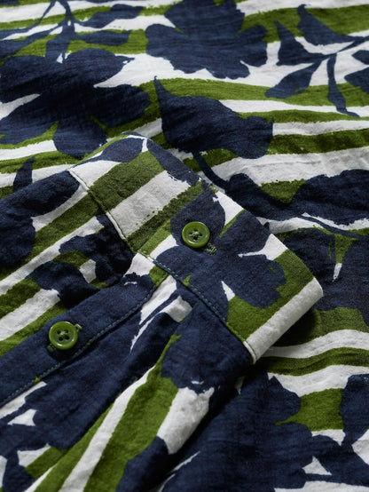 Close-up of a floral patterned fabric with blue, green, and white colors.