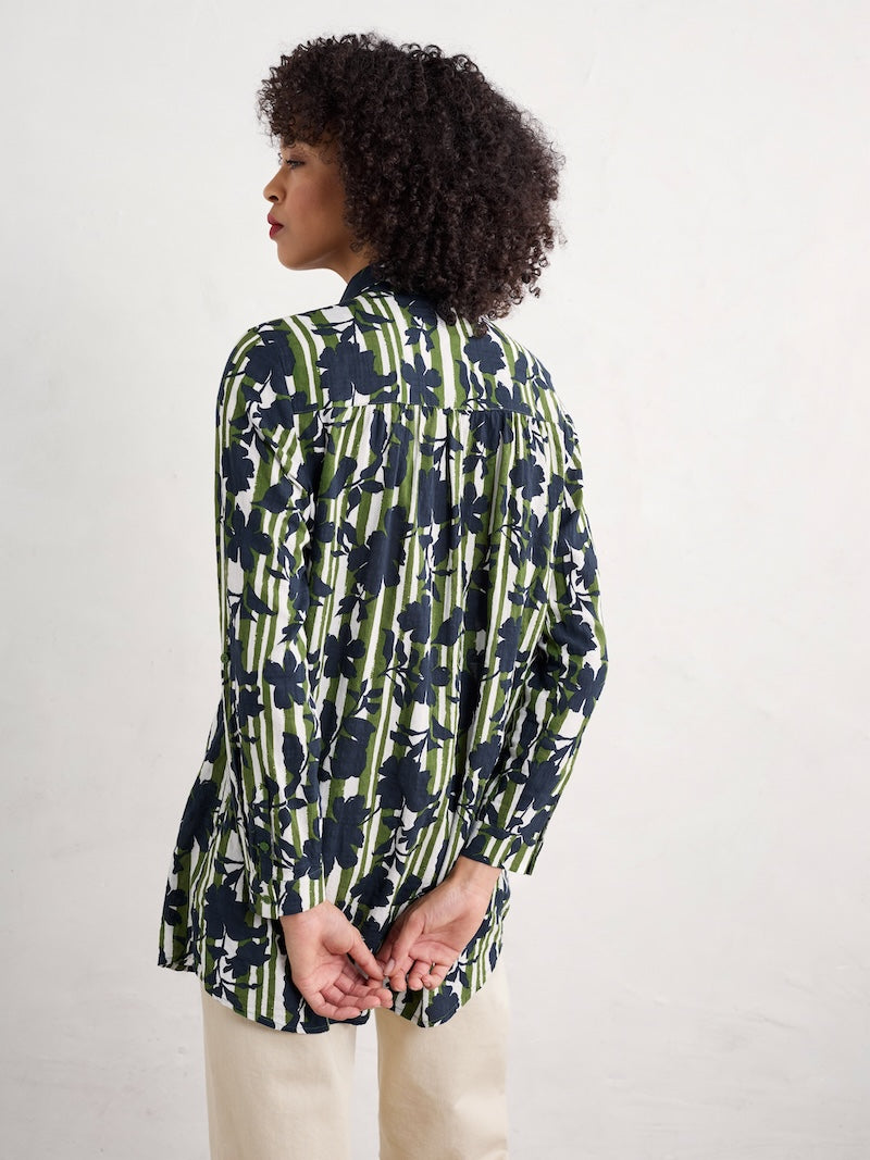 Woman wearing a floral patterned blouse against a white background