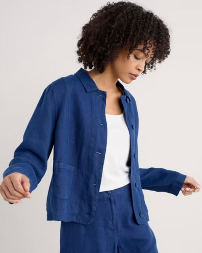 Woman wearing a blue jacket and pants on a plain background