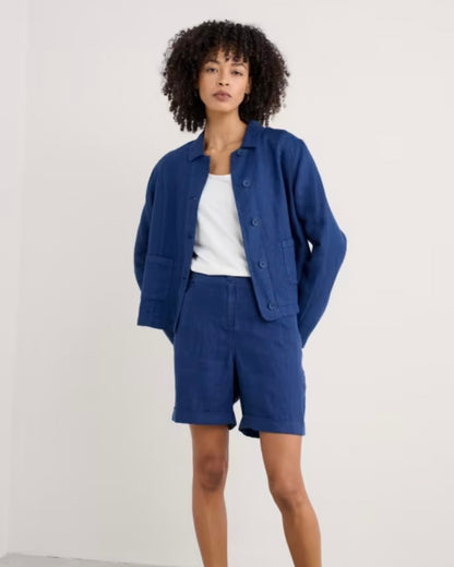 Woman wearing a blue jacket and shorts set on a white background