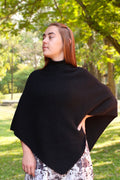 Woman wearing black possum & merino wool poncho in park