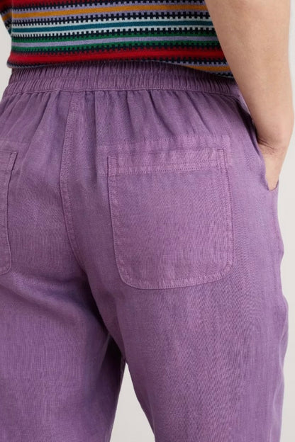 Purple pants with a striped top on a neutral background