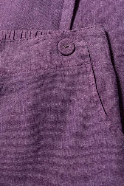 Close-up of a purple fabric with a button on a dark background