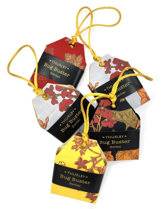 Four hanging herbal tea tags for Thurlby Bug Buster, each with a different color block (red, white, black, yellow) decorated with orange and brown botanical illustrations, on a white background.