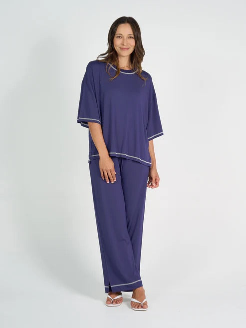 Woman wearing navy blue bamboo shirt and pant set on a white background