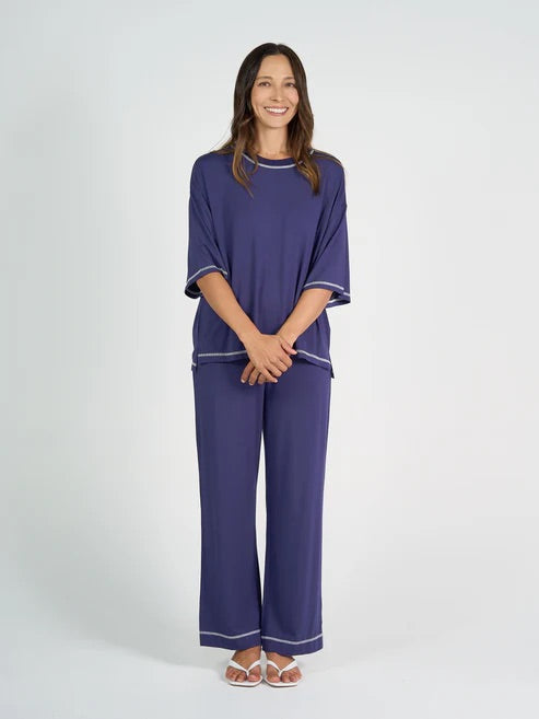 Woman wearing a blue bamboo shirt and pant set on a white background