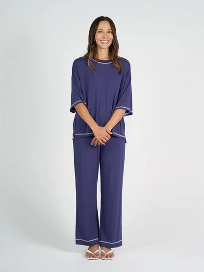 Woman wearing a blue bamboo shirt and pant set on a white background