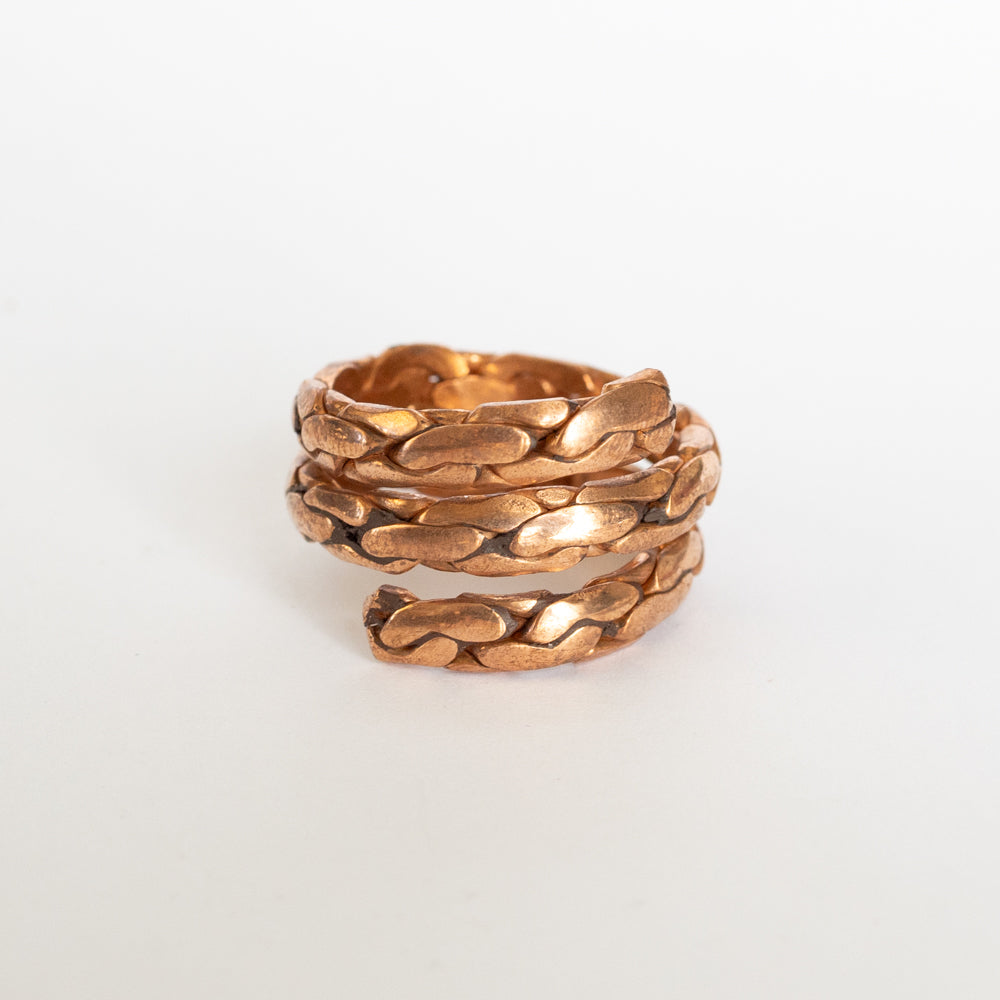 Copper textured twisted ring on white background