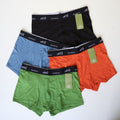 Mens bamboo boxers laying on a table. Showing 4 colours that are included in pack - blue, black, orange and green