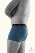 Men's undies blue boxers with black band on male model side view