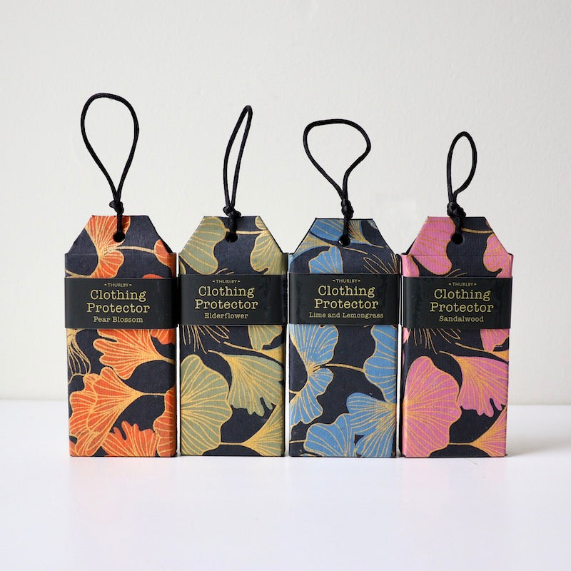 4 different scents of clothing protectors sitting on table with strings on each for hanging in wardrobe