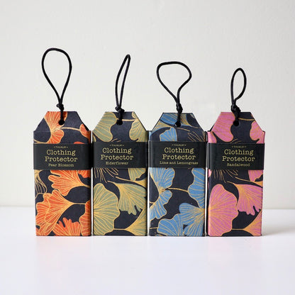 4 different scents of clothing protectors sitting on table with strings on each for hanging in wardrobe