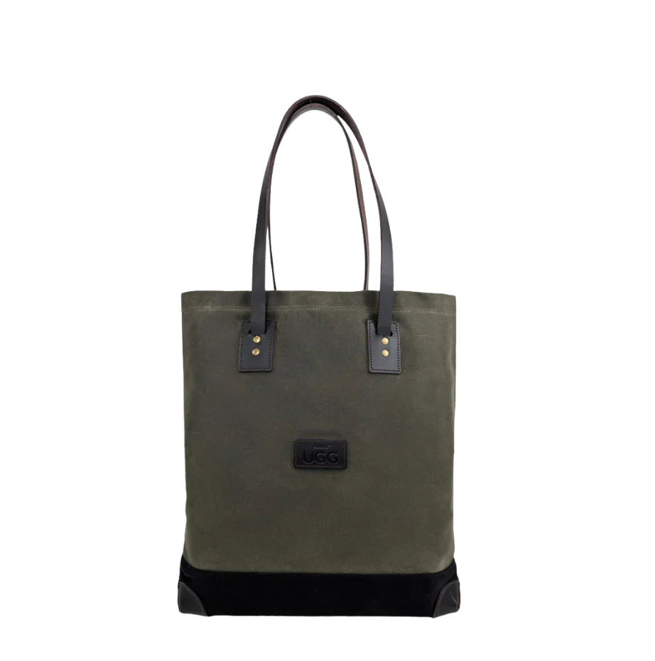 Green canvas tote bag with black leather accents on a white background