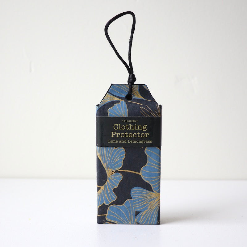 Lime & Lemongrass scented clothing protector sitting on table with string for hanging in wardrobe