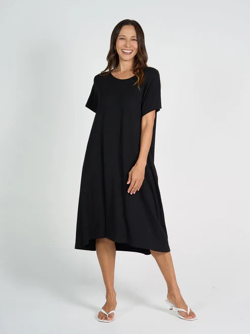 Woman wearing black bamboo knee length dress on white background.