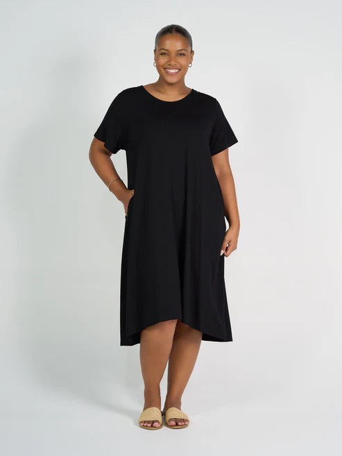 Woman wearing black bamboo knee length dress on white background.