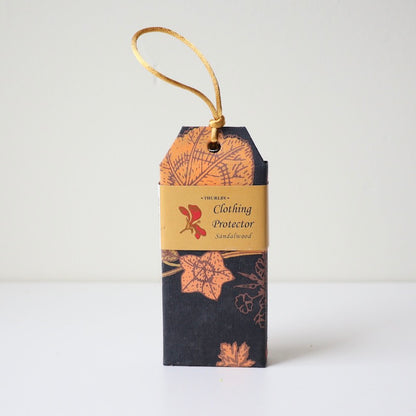 Sandalwood scented clothing protector moth repellent sitting on table with string on top for hanging in wardrobe