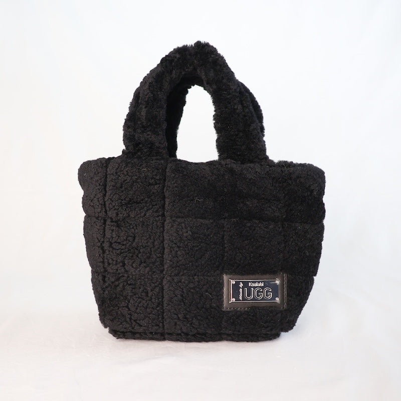Black sheepskin handbag with a visible brand logo on a white background