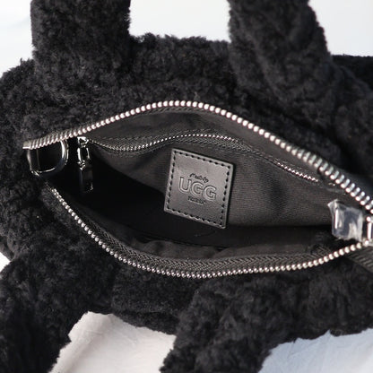 Black UGG bag with open zipper showing brand logo on a white background