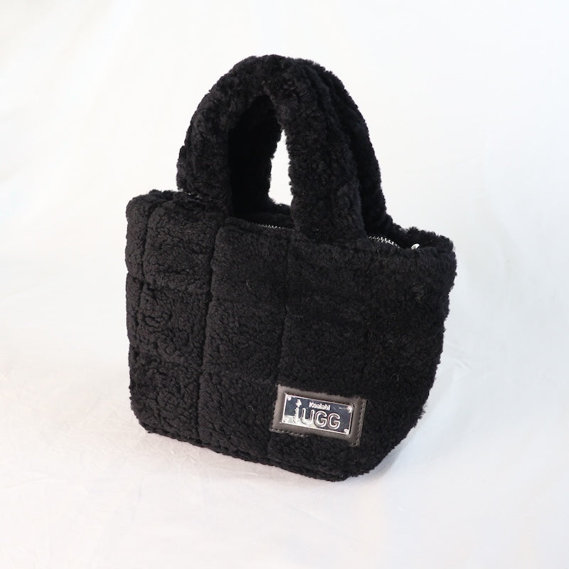 Black sheepskin handbag with a visible brand label on a white background