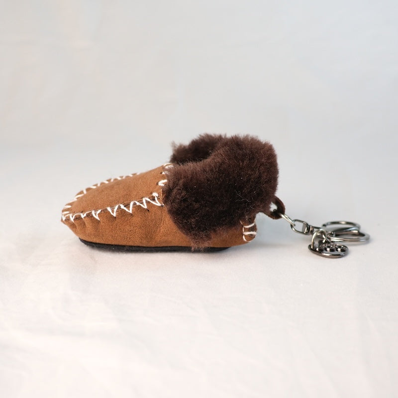 Brown moccasin-shaped keychain with fur trim on a white background