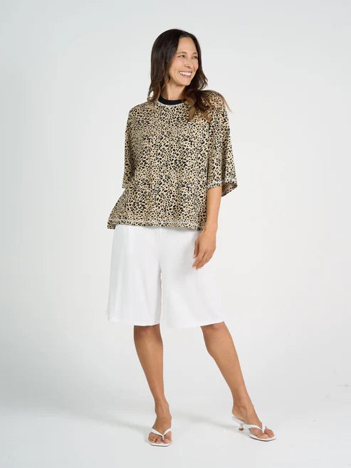 Woman wearing a leopard print bamboo top and white bamboo shorts on a white background