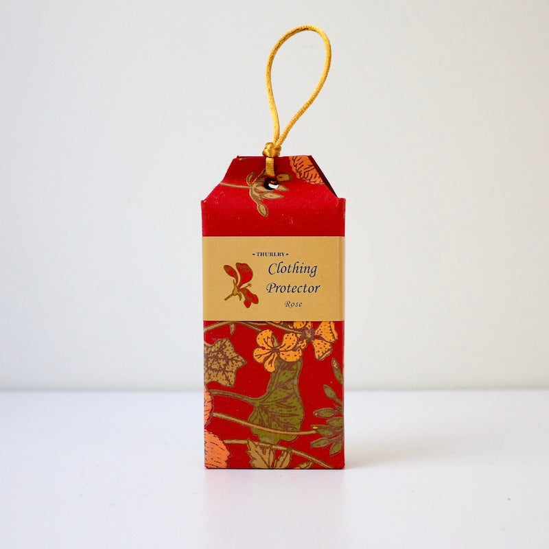 Rose scented clothing protector moth repellent sitting on table with string on top for hanging in wardrobe