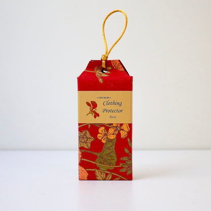 Rose scented clothing protector moth repellent sitting on table with string on top for hanging in wardrobe