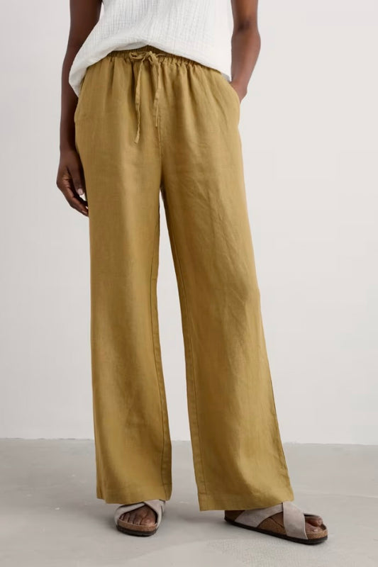 Person wearing mustard yellow wide-leg pants on a plain background
