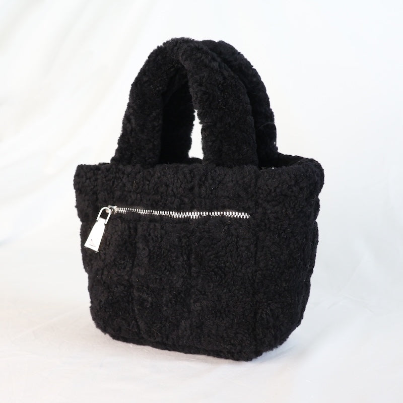 Black sheepskin handbag with a silver zipper on a white background