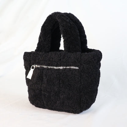Black sheepskin handbag with a silver zipper on a white background