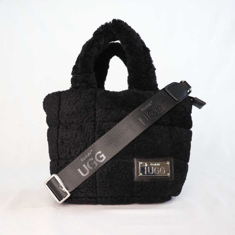 Black sheepskin handbag with UGG strap on a white background