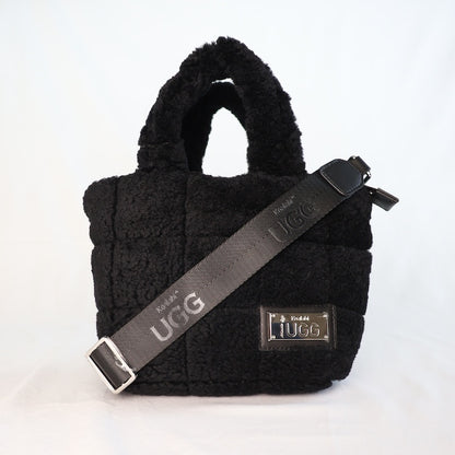 Black sheepskin handbag with UGG strap on a white background