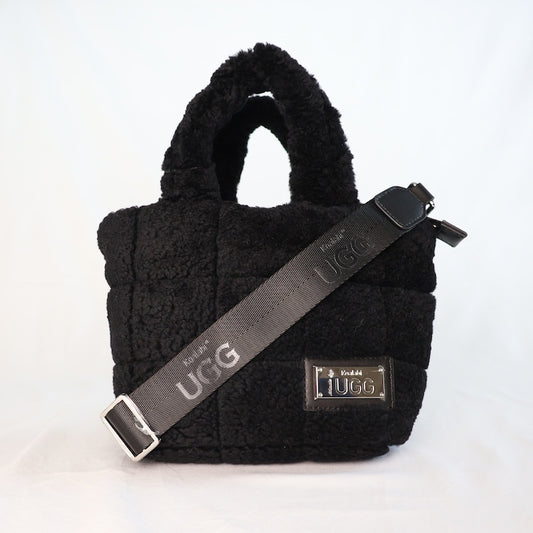 Black sheepskin handbag with UGG strap on a white background