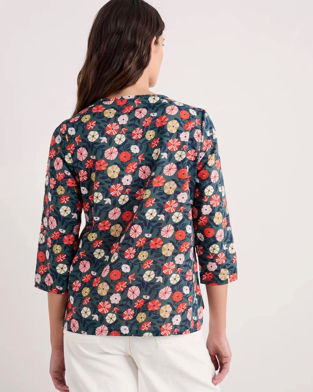 Woman wearing a floral blouse with a plain background
