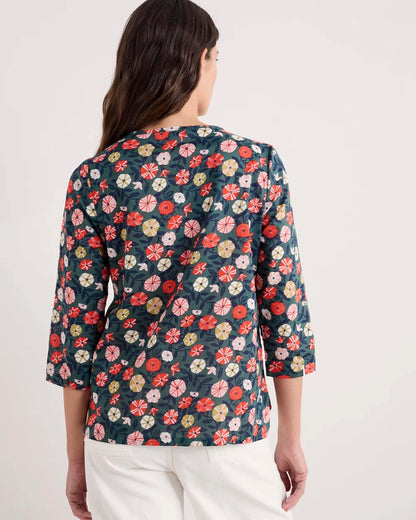 Woman wearing a floral blouse with a plain background