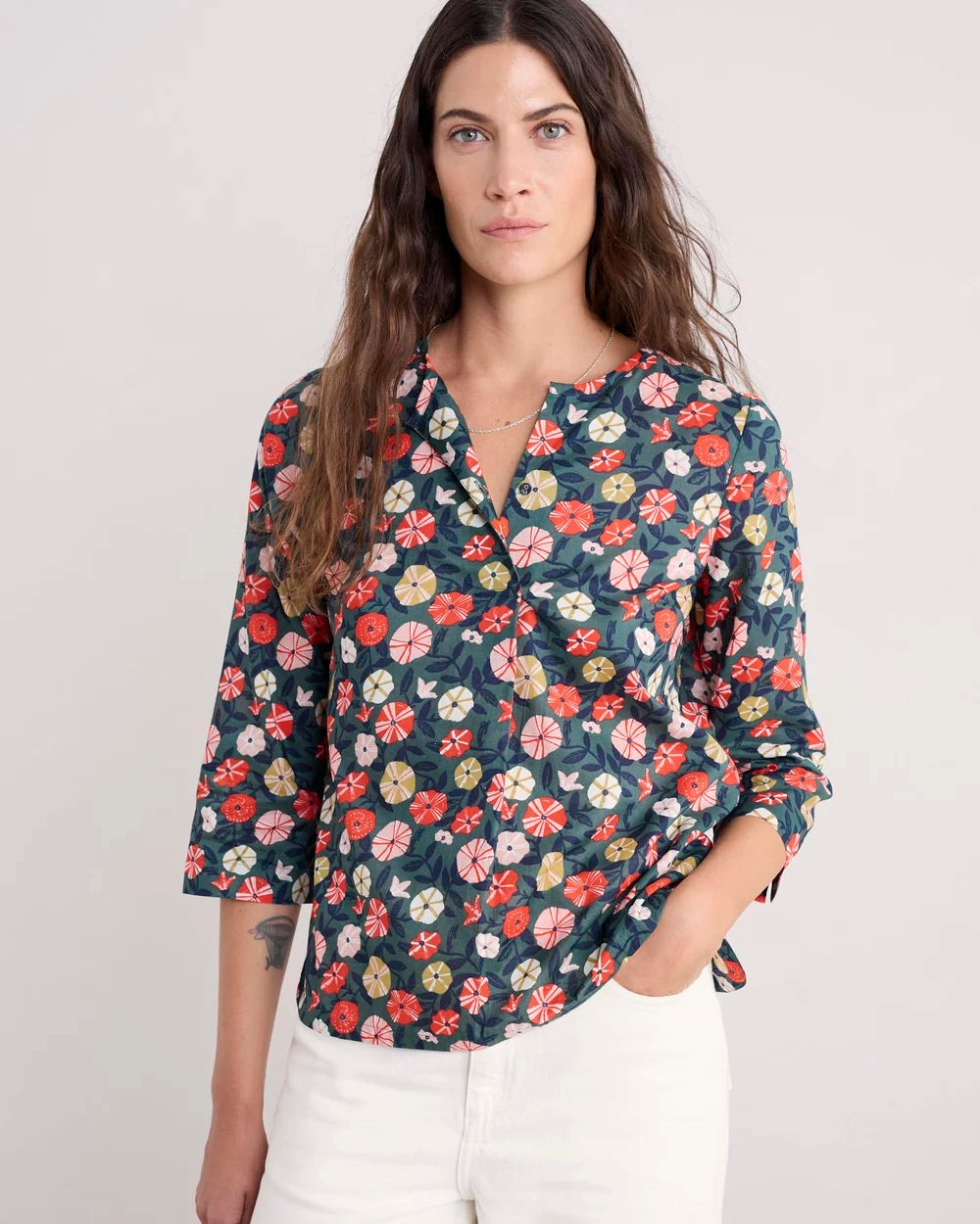 Woman wearing a floral blouse with a plain background